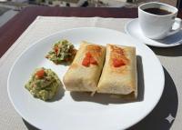 a white plate with two sandwiches and a cup of coffee at HOSTAL COMFORT INN Torre A in Quito
