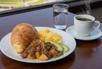 a plate of food with meat and bread and a cup of coffee at HOSTAL COMFORT INN Torre A in Quito