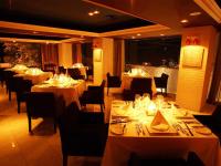 un ristorante con tavoli e sedie con tavoli bianchi di Relax Resort Hotel ad Atami
