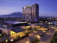 Un gran edificio con una montaña al fondo. en Grand Mercure Malang, en Malang