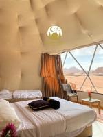 a bedroom with two beds and a view of the desert at Golden Galaxy Luxury Camp in Wadi Rum