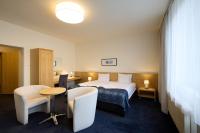 Una habitación de hotel con una cama, una mesa y sillas. en Hotel Laterum, en Pécs
