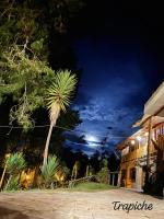 a palm tree in front of a building at night at EL TRAPICHE in Sigchos