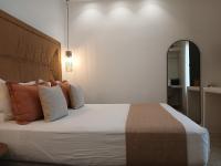Un dormitorio con una cama grande con almohadas naranjas. en Anais Of Naxos, en Agia Anna de Naxos