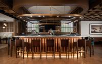 un bar en un restaurante con sillas alrededor en The Elmore Hotel, DFW Southlake, a Tribute Portfolio Hotel, en Southlake