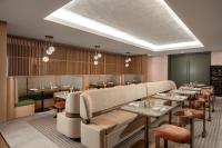 Un restaurante con mesas y sillas en una sala. en The Elmore Hotel, DFW Southlake, a Tribute Portfolio Hotel, en Southlake