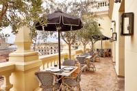 a balcony with tables and chairs and an umbrella at The Principal Madrid, Small Luxury Hotels in Madrid