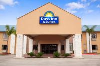 una posada y un edificio de suites con un cartel en Days Inn &amp; Suites by Wyndham Conroe North, en Conroe