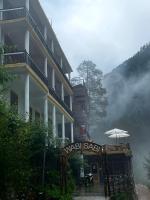 a hotel with an umbrella in front of a building at Wabi Sabi Hostel in Kasol