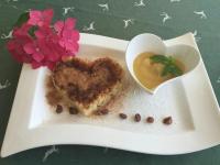 Un plato blanco con un postre en forma de corazón y un tazón de comida en forma de corazón. en Hotel Prechtlhof, en Althofen