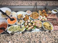Un buffet de diferentes tipos de comida en una mesa. en Hôtel Restaurant le Privilège - authentic by balladins, en Verdún