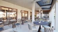 un ristorante con tavoli, sedie e finestre di ARATO by E-GEO, Adults Only a Città di Kos