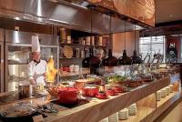 a chef preparing food in a large kitchen at Luxanova Panorama Condotel in Nha Trang