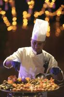 Un chef de pie frente a un plato de comida. en Nandi Daybreak - Holiday Homes, en Bangalore