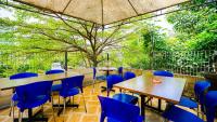 BlimbingにあるNovon Family Hotel by Tripletreeの青い椅子とテーブル、木のあるレストラン