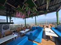 a restaurant with blue couches and tables with a view at Hotel Savaya Luxury Stay Near AIIMS Rishikesh in Rishīkesh