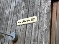 Exclusive FEWO in Warnemünde, 150m to the beach, 2 bathrooms, 2 bedrooms, sauna, WiFi and much more. في روستوك: علامة على جانب الجدار الخشبي