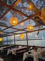 Un restaurante con mesas y candelabros y el océano. en Jurubeba Hotel de Charme, en Belém
