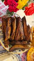 a plate of fried food on a table with flowers at Pensiunea Agroturistica Cerna, Vaideeni - Polovragi in Vaideeni