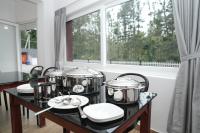 um conjunto de panelas e frigideiras sobre uma mesa com uma janela em Pallakki Comforts Chikmagalur em Attigundi