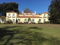 ein großes gelbes Haus mit einem großen Garten in der Unterkunft Luxury Villa Pembe Palheiro Village by Holiday Rental Madeira in Funchal