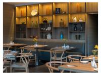 una sala da pranzo con tavoli e sedie in legno e scaffali di Casa Grande Suites a La Paz