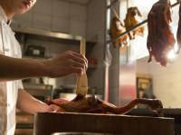 a person cutting a piece of meat with a knife at Hotel Dùa in Kaohsiung