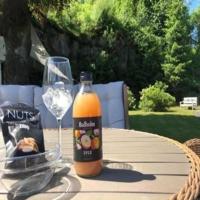 Una botella de jugo sobre una mesa con un vaso. en Førde Hotel - Unike Hoteller, en Førde