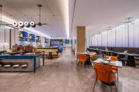 a restaurant with orange chairs and tables and tablesktop at Novotel Shanghai Hongqiao International Airport in Shanghai