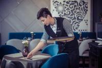 um homem segurando uma bandeja de comida em uma mesa em Feeling Parent-Child Family Hotel Xi'an em Xian