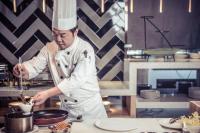 Um chef está a preparar comida numa cozinha. em Feeling Parent-Child Family Hotel Xi'an em Xian