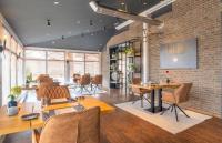 a restaurant with tables and chairs and a brick wall at Komfort-Hotel Katerberg in Lüchow