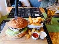 een hamburger en frietjes op een dienblad met een drankje bij Apartament Harmony in Tychy
