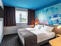Una habitación de hotel con una cama y un cuadro en la pared. en B&amp;B Hotel Wolfsburg-Weyhausen, en Wolfsburg