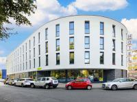 a white building with cars parked in front of it at B&amp;B HOTEL Wuppertal City-Süd in Wuppertal