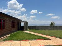 a brick house with a grassy yard next to a building at The Trekkers Rest Lodge Kigali in Kigali