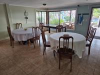 uma sala de jantar com duas mesas e cadeiras em Jane's Beach Resort em Chacarita