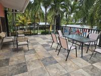 um pátio com uma mesa e cadeiras e uma cerca em Jane's Beach Resort em Chacarita