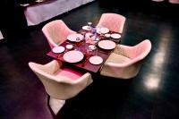 een tafel met roze stoelen en een tafel met borden erop bij adiMOUNT-Kumaon Eco Resort in Dwārāhāt