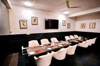 een vergaderzaal met een lange tafel en witte stoelen bij adiMOUNT-Kumaon Eco Resort in Dwārāhāt