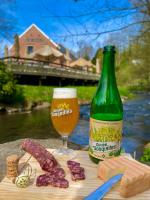 een fles bier naast een tafel met een glas bij Gîte du Marquis in Gussignies