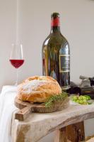 una botella de vino y una hogaza de pan y un vaso en Pousada Rabo do Lagarto, en Pedra Azul