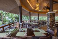 Acuaverde Beach Resort في سان خوان: مطعم بطاولات وكراسي وبلكونه