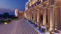 a building with tables and chairs and a clock tower at Umaid Bhawan Palace Jodhpur in Jodhpur