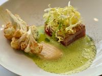 a plate of food with meat and sauce on it at Romantik Waldhotel Mangold in Bergisch Gladbach