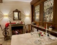 a dining room with a table and a fireplace at Romantik Waldhotel Mangold in Bergisch Gladbach