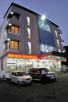 un hotel con coches estacionados frente a un edificio en KDM Hotel Sai Geeta Shirdi a walk away from Saibaba Temple, en Shirdi