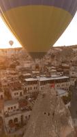 un globo de aire caliente volando sobre una ciudad en Carus Cappadocia, en Göreme