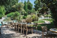 Un patio con mesas y sillas y una piscina. en Setclub Hôtel & Spa Aix-en-Provence, en Aix-en-Provence