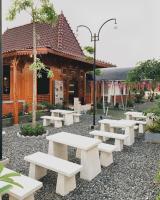 un grupo de bancos blancos frente a un edificio en Gomini Stay, en Cebongan